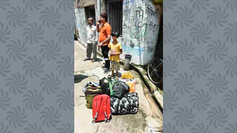 People wait with their belongings in Durga Pituri Lane on Thursday 