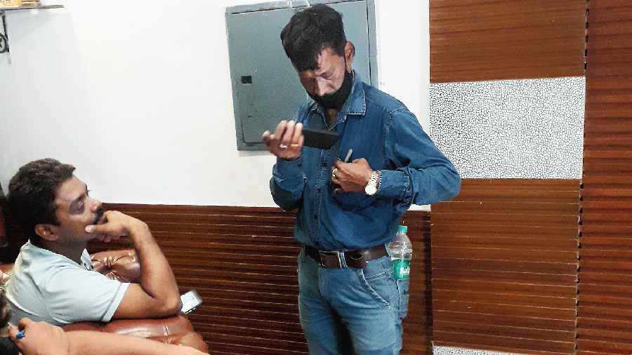 A KMRC official speaks to Raj Kumar Chaurasia (left) at a hotel in central Kolkata on Friday. Chaurasia was evacuated  from his home in Durga Pituri Lane on Wednesday.