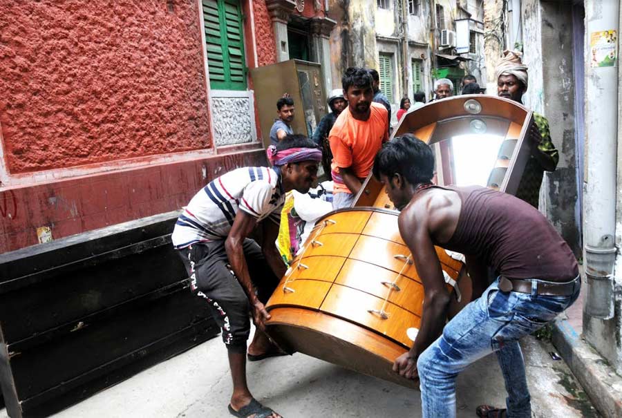 SAFETY FIRST: Workers lift a piece of heavy furniture during evacuation of a family from Durga Pituri Lane in Bowbazar on Friday, May 13. Around 30 houses in the neighbourhood developed cracks two days earlier.  