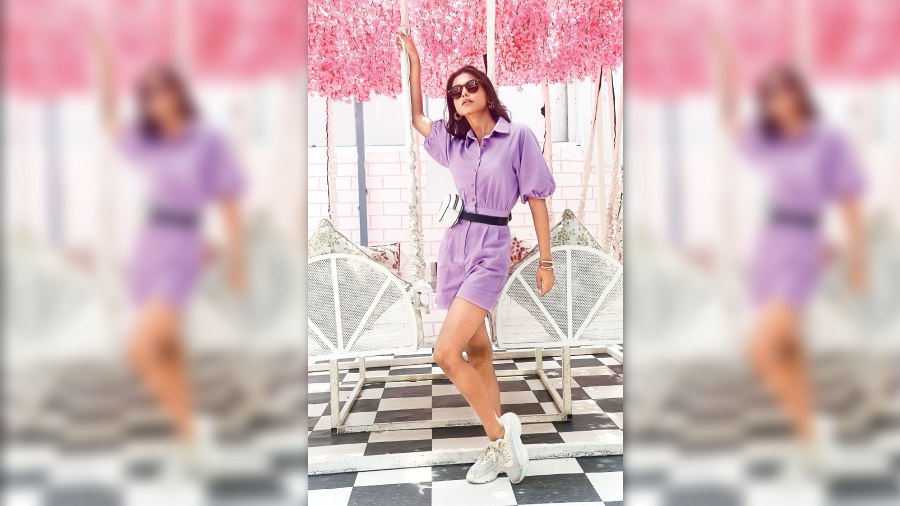 Neha picks this easy-breezy romper for the Very Peri day look. “We have styled it cute and fun, to distinguish how this colour can go from day to night. We have given her sneakers with it and a belt bag,” she says. Open, wavy hair, sunglasses and minimal accessories complete the happy look.