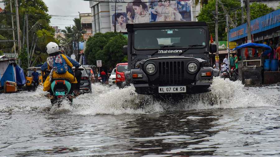  Vehicles wade through a waterlogged road after heavy rain