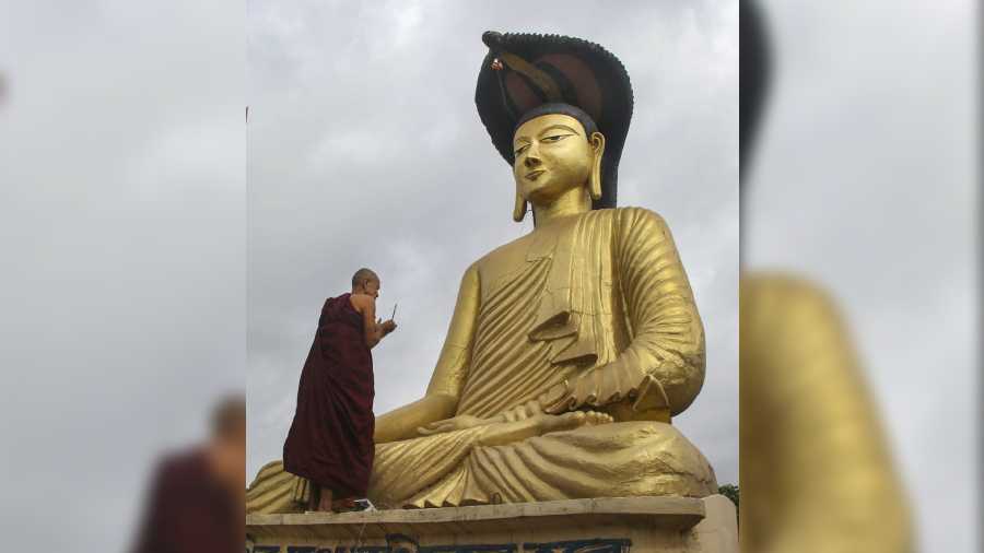  A Buddhist monk lights candles in front of a Buddha statue on the occasion of Buddha Purnima festival, in Agartala