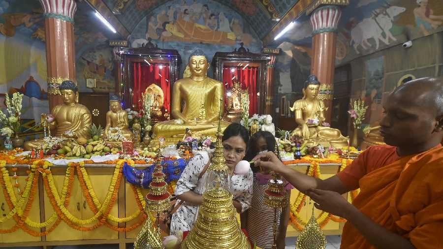 Devotees look at the golden tomb replica believed to contain a relic of Lord Buddha, at Mahabodhi Society in Calcutta