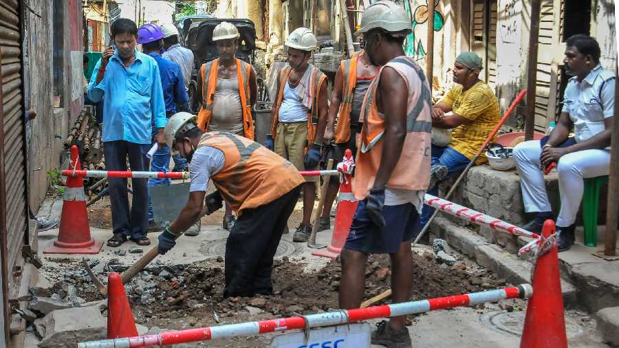 Calcutta Electricity Supply Corporation (CESC) workers perform repair work after cracks appeared on several buildings, likely to have been caused by metro railway construction at Bowbazar area