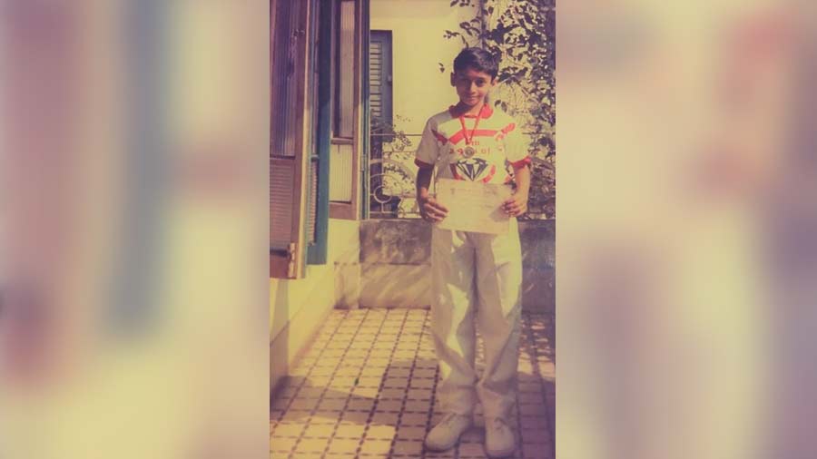 A young Kaushik at his New Alipore house, holding an accolade from his school 