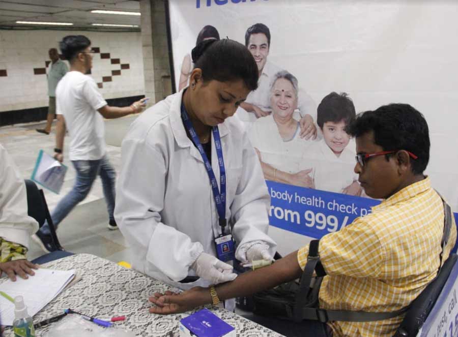 A healthcare professional performs tests on a Metro commuter. Free health check-up camps were organised at various Metro stations on Wednesday