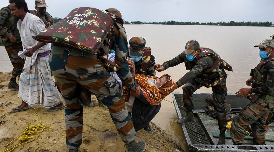 Army personnel evacuate flood-affected villagers during relief operations after heavy rainfall, in Hojai district