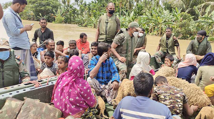 Army personnel evacuate people during flood relief operations after heavy rainfall, in Hojai district