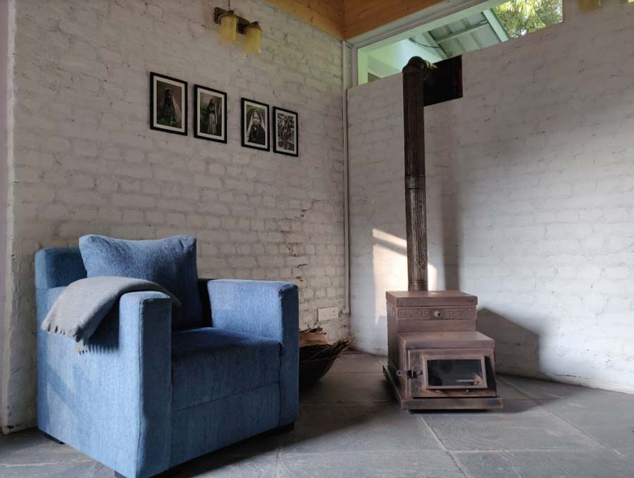 A comfortable sofa chair and a wood-fired stove makes up this corner