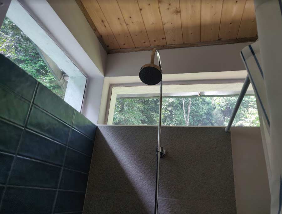 Light-filled washrooms are fitted with overhead showers. Even the washrooms offer a glimpse of the forest! 