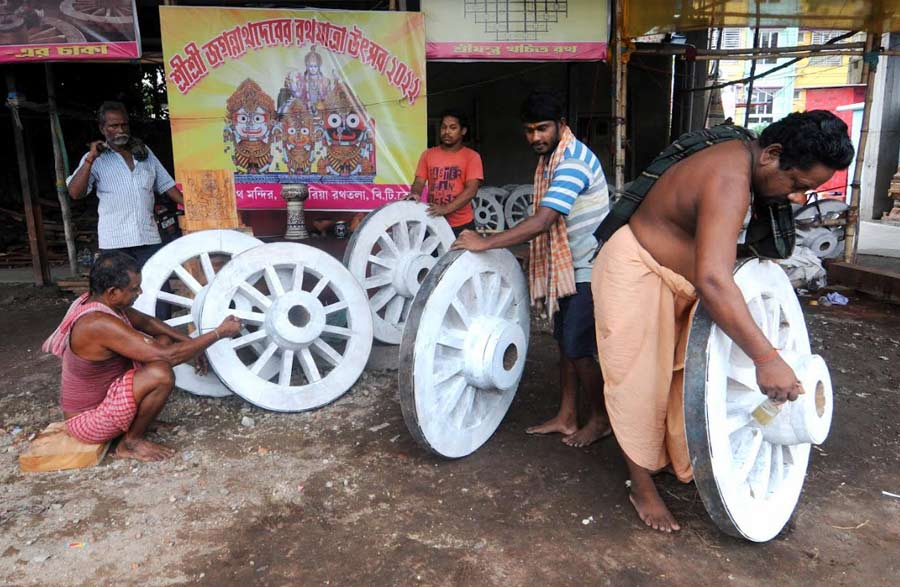 Workers from Odisha paint the wheels of a chariot which will be used during a Rath Yatra procession in the city. Rath Yatra is on July 1 this year