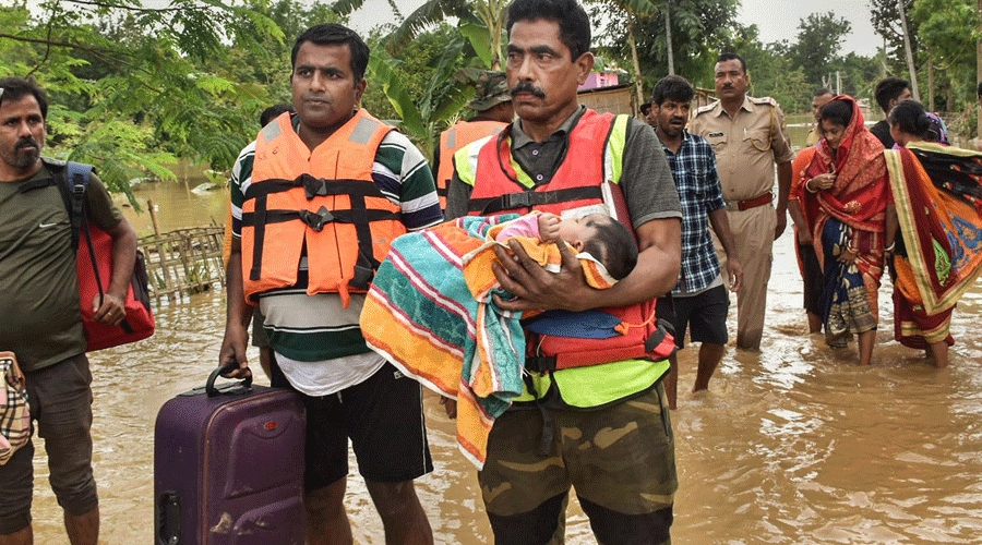 SDRF personnel rescue people from a flood affected village in Assam's Hojai district on Thursday.