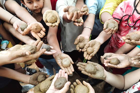 Students learn to make seed balls from clay.