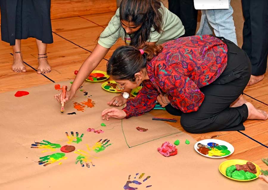 The workshop ended with a group art session where everyone drew a symbol on the same parchment paper that represented what the workshop did for them. One participant drew baby feet which signified the childhood nostalgia the pre-school brought back, two others drew colourful handprints and a rainbow that signified the burst of colour the workshop was, another participant drew a spiral that signified the thoughts we often have while introspecting and two others drew hearts with each of their fingerprints