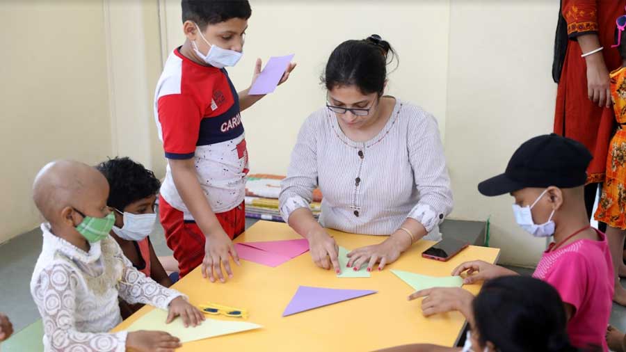 Bhaskar (standing) taking art and craft lessons from Madhumita Bera