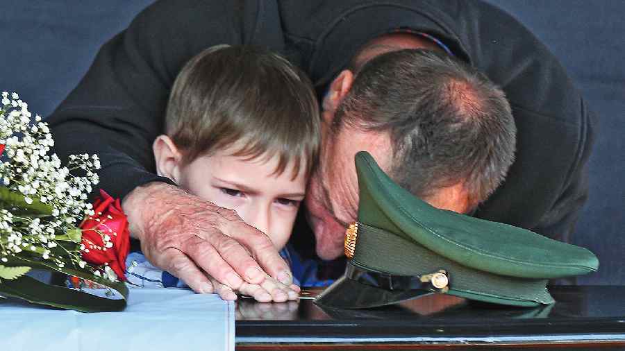 Father and son of Russian Army Sergeant Daniil Dumenko, who was killed during fighting in Ukraine, mourn during a farewell ceremony in Volzhsky, outside Volgograd, Russia, on Thursday. 