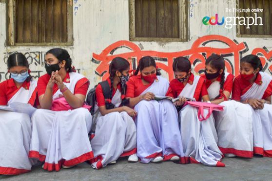 Class X students revise their syllabus before appearing for the first exam of Madhyamik 2022 outside an examination centre in Kolkata on March 7.