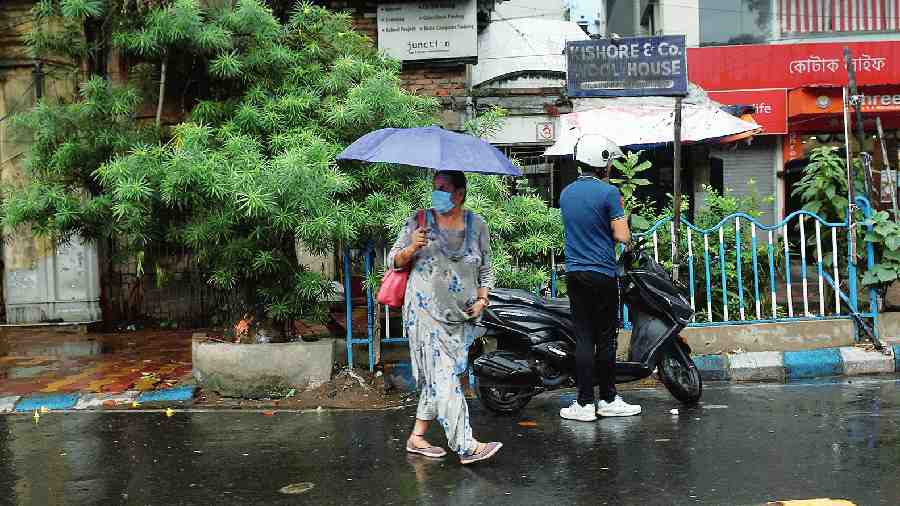 Pedestrians caught in rain in Bhowanipore on Sunday afternoon. 