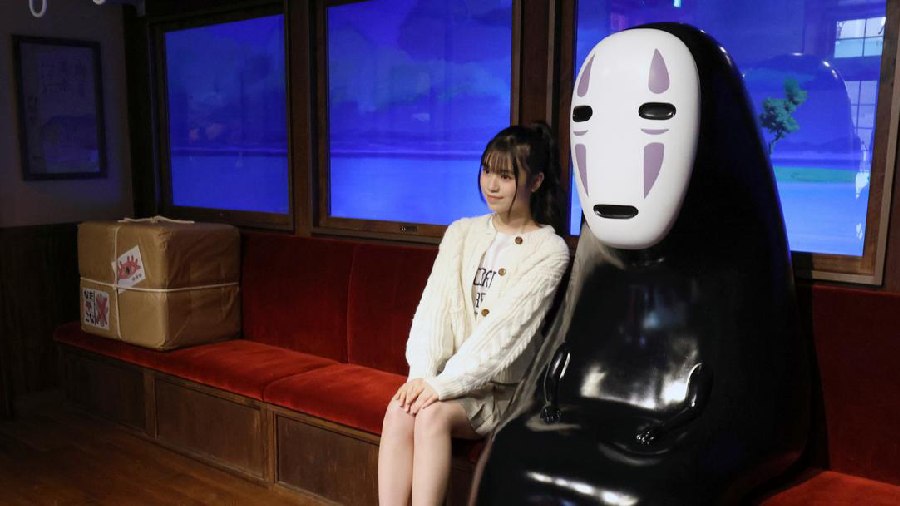 A girl poses with the No-Face character from the film 'Spirited Away'