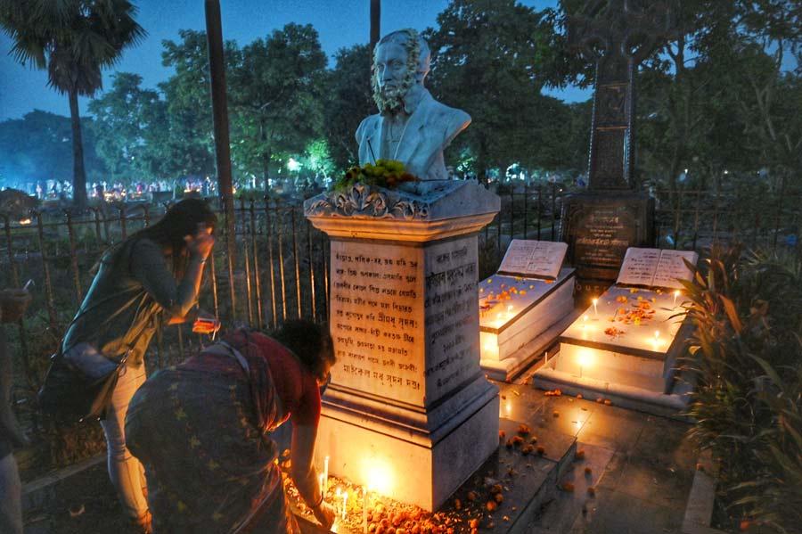 People light candles at the grave of poet and playwright Michael Madhusudan Dutta
