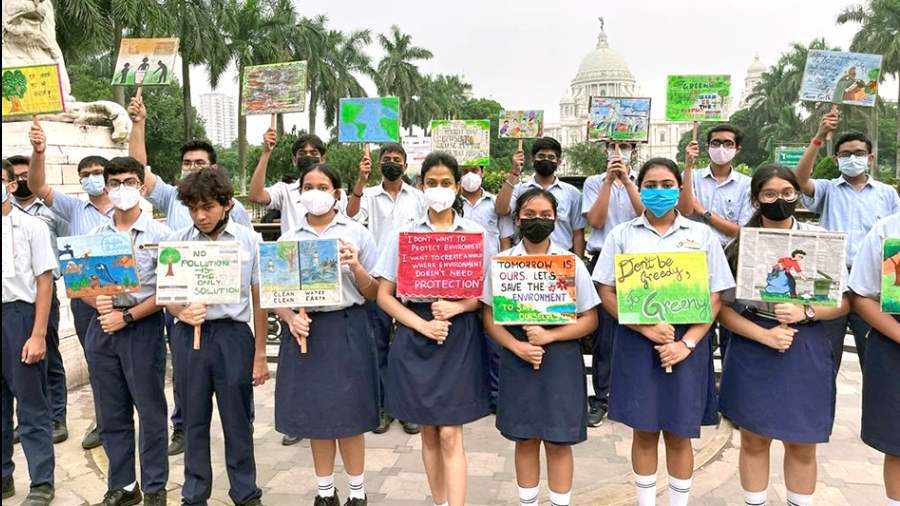 Students of classes VI to XII of South Point High School hold placards on nature conservation in front of Victoria Memorial
