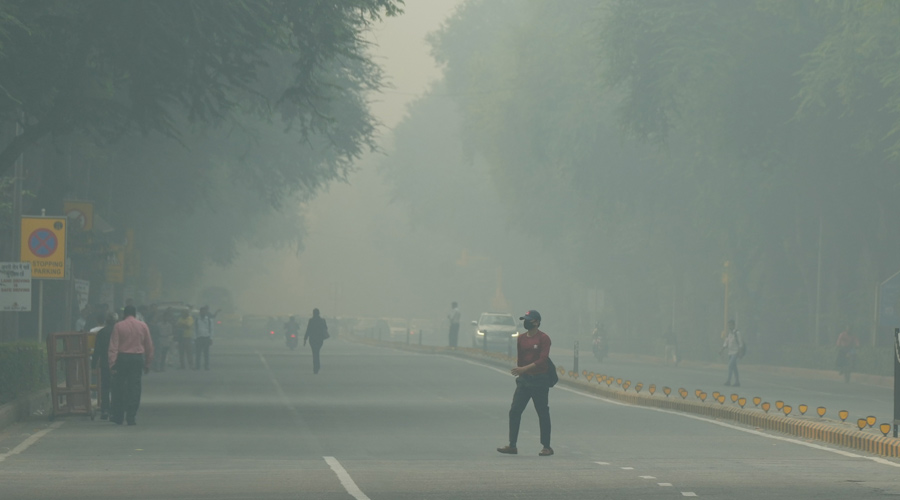 A man crosses a road, shrouded in a thick layer of smog in New Delhi.