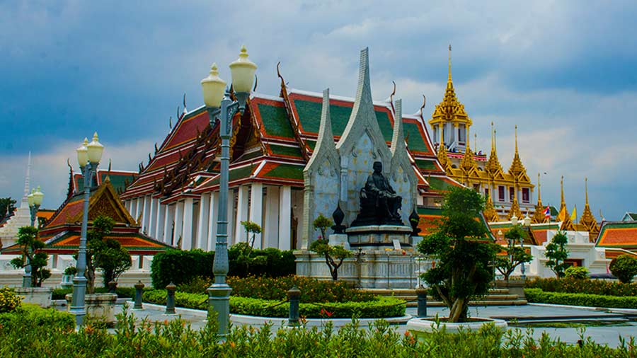 The statue of King Rama III with the Loha Prasat complex in the background 