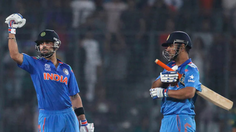 Kohli, alongside M.S. Dhoni, after India’s victory against South Africa, at the 2014 T20 World Cup