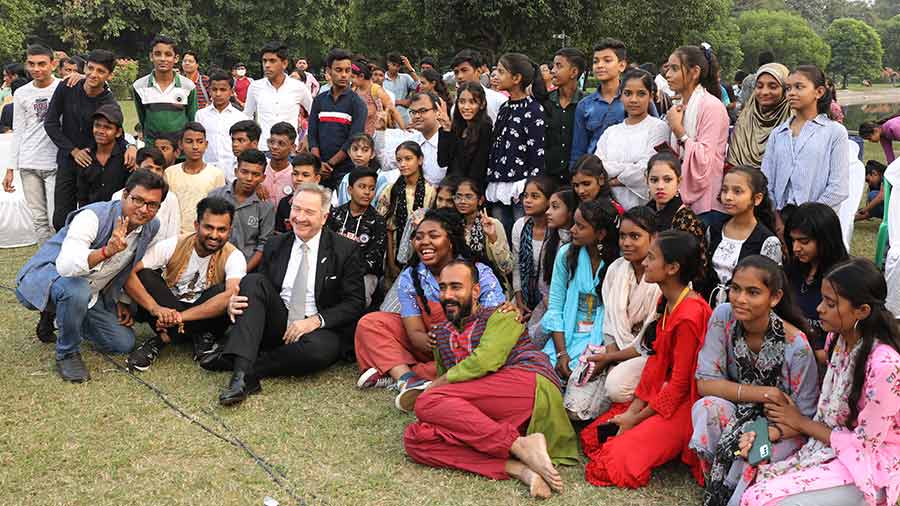 Adrian Pratt, public diplomacy officer, US consulate, and performers pose for a photograph with the audience