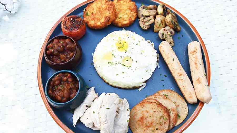 The High Protein Breakfast Platter is a great plate for weight-watchers to indulge in as it packs the goodness of sunny-side-up eggs, chicken sausage, boiled chicken, chicken salami, and mushrooms.