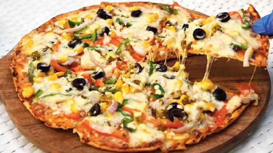 Pizza lovers do try this crunchy bite, the Pizza Caprina. A thin-crust base with toppings such as bell peppers, onions, jalapeno, black olives and  American corn.