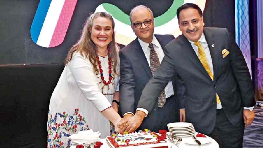 The consul general cuts a cake along with Vivek Kumar and JW Marriott general manager Sumit Suri