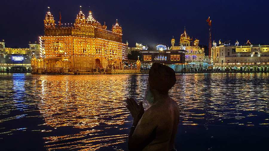 A Sikh devotee takes a dip in the holy 'sarovar' at Golden Temple on the eve of the birth anniversary of Guru Nanak Dev in Amritsar