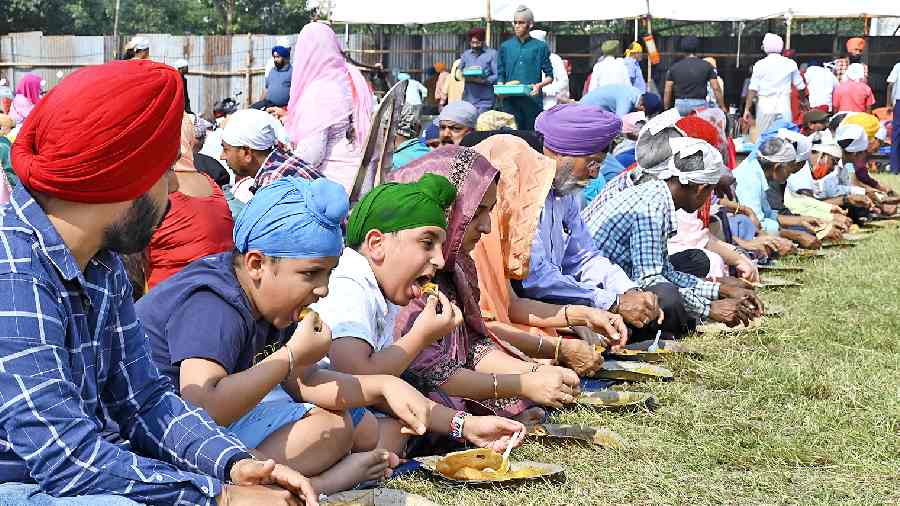 Devotees at the langar held on the occasion of the 553rd birth anniversary of Guru Nanak, on the Maidan on Tuesday. 