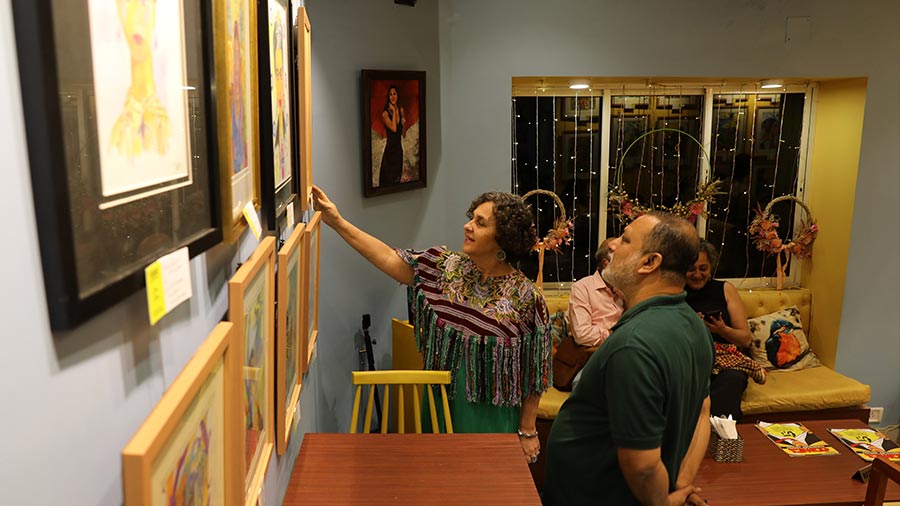 Jael Silliman talks about one of her paintings with a visitor at the exhibition