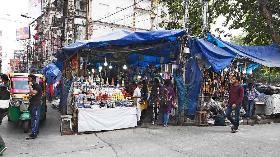 A cluster of stalls covered with plastic sheets, and occupying nearly half the width of the footpath, near the Gariahat crossing on Wednesday afternoon. Hawking rules say plastic sheets cannot be used and hawkers cannot occupy more than a third of the width of a footpath.