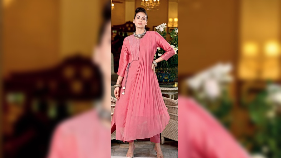 This half-half coral georgette kurta with pleating on one side and a stylish yoke with tassel detailing on the other side, is simple yet stunning as daywear