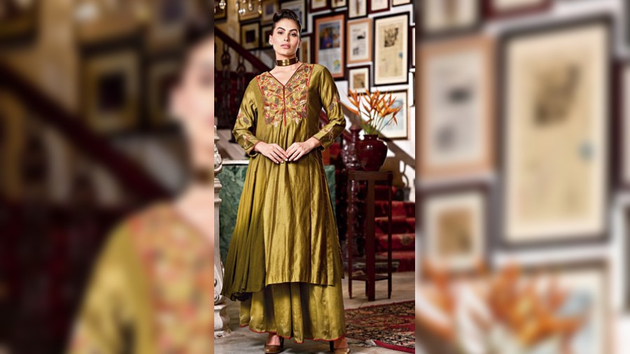 The olive green ombre silk panelled kurta features floral embroidery on the yoke and is detailed with crimson edging. Paired with a sharara, the outfit is perfect for the mehndi occasion for the autumn-winter wedding season