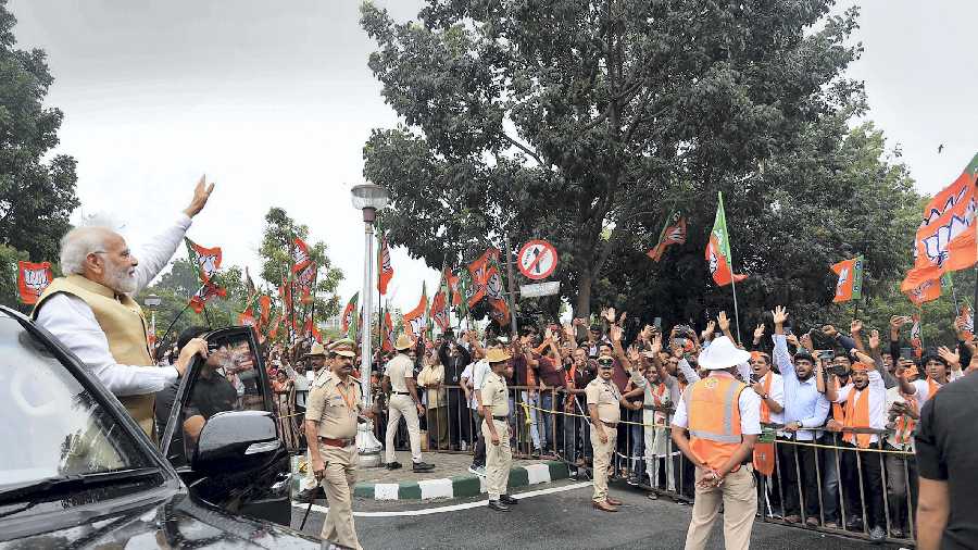 Prime Minister Narendra Modi waves at supporters gathered to welcome him during his visit to Bengaluru, Friday, November 11, 2022. 