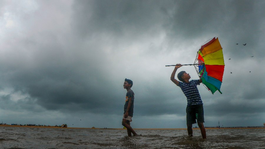 Youngsters play at the flooded Marina Beach following incessant rains