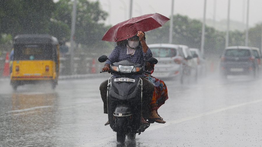 Commuters ride a two-wheeler amid incessant rainfall amid heavy downpour