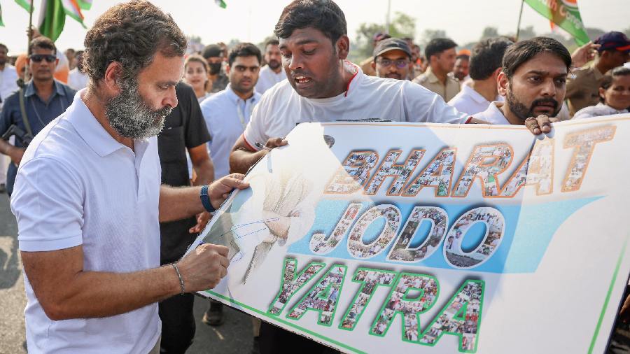 Congress leader Rahul Gandhi signs the placard of a supporter during the party's 'Bharat Jodo Yatra', in Hingoli district, Saturday, November 12, 2022