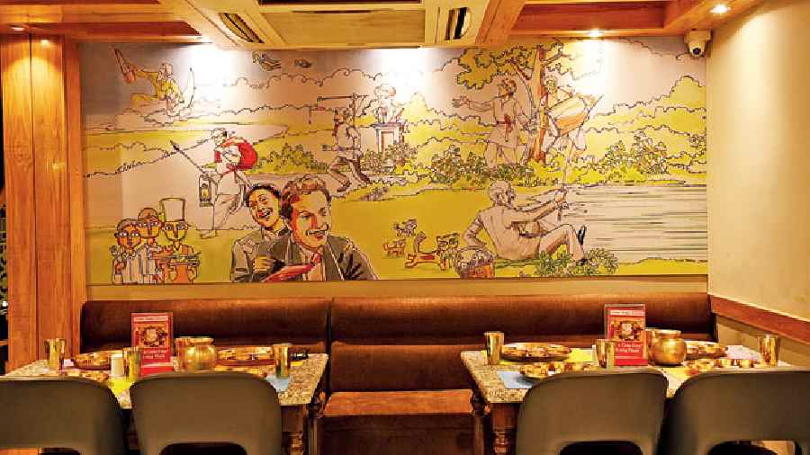 The interiors are kept subtle and fresh with cream walls, wooden structures, paintings dedicated to Uttam Kumar’s song Ei poth jodi na sesh hoi, baul sangeet and others too add the bangaliana to the restaurant