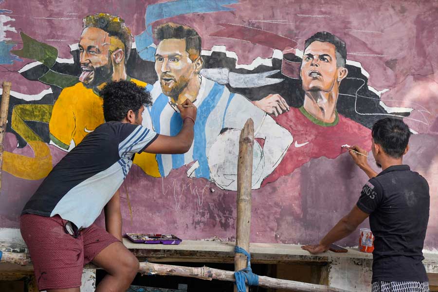 Fans create a mural featuring football stars Lionel Messi, Neymar Jr and Cristiano Ronaldo ahead of the upcoming FIFA World Cup Qatar 2022, in Kolkata on November 16