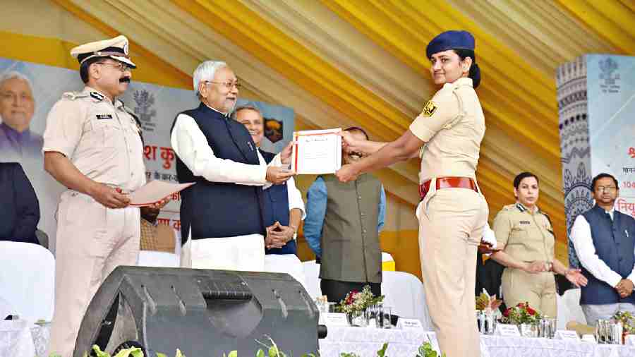 Nitish Kumar hands over appointment letters to a woman police personnel in Patna on Wednesday. 