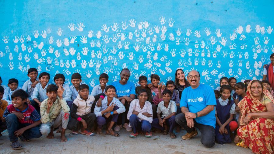 UNICEF volunteers in India pose with the children from Mandu village in Madhya Pradesh on World Children's Day. 