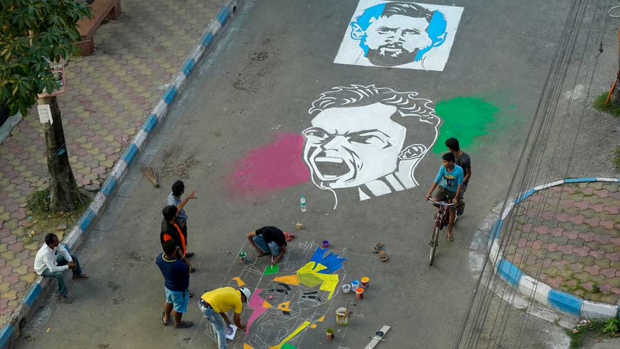 Fans create a mural at a city street featuring football stars Lionel Messi, Neymar Jr and Cristiano Ronaldo in the city. 