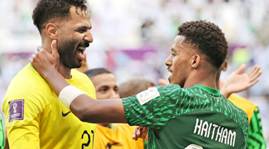 Saudi Arabia goalkeeper Mohammed Al-Owais (in yellow) celebrates with a teammate after the win.
