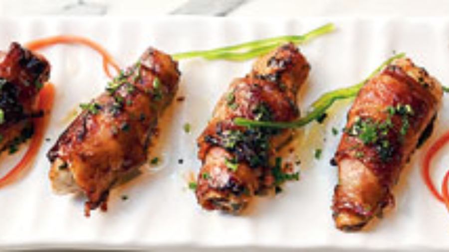 Gangster Wrapper: Boneless chicken marinated with aromat powder, crushed pepper, oregano and chilli flakes is wrapped like a baby with crispy bacon belts and sauteed with BBQ sauce