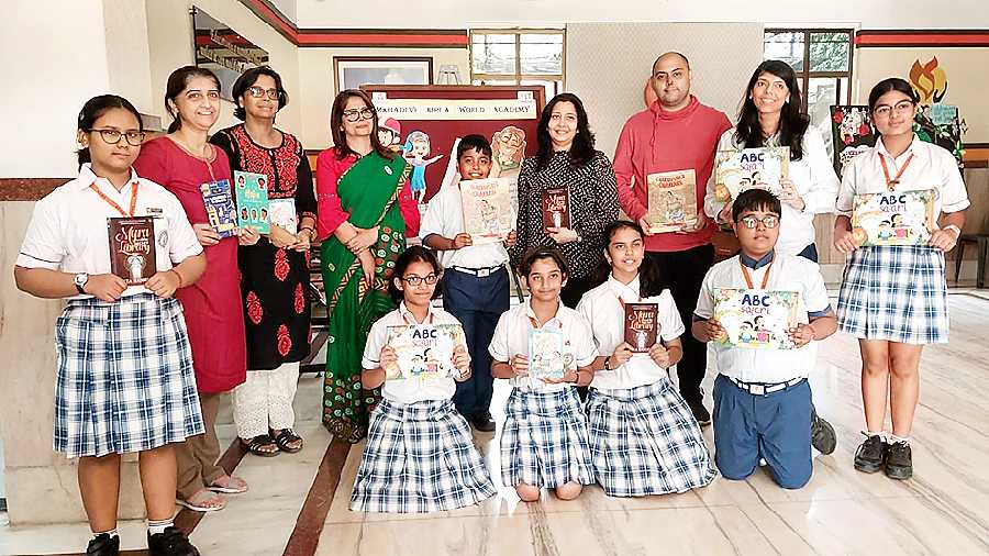 Students, headmistress Nupur Ghosh (in green sari) and the authors hold their books at the literature festival